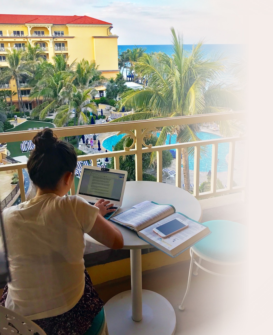 Student studying on her laptop on a hotel balcony