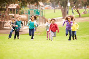 A small group of children running on grass.