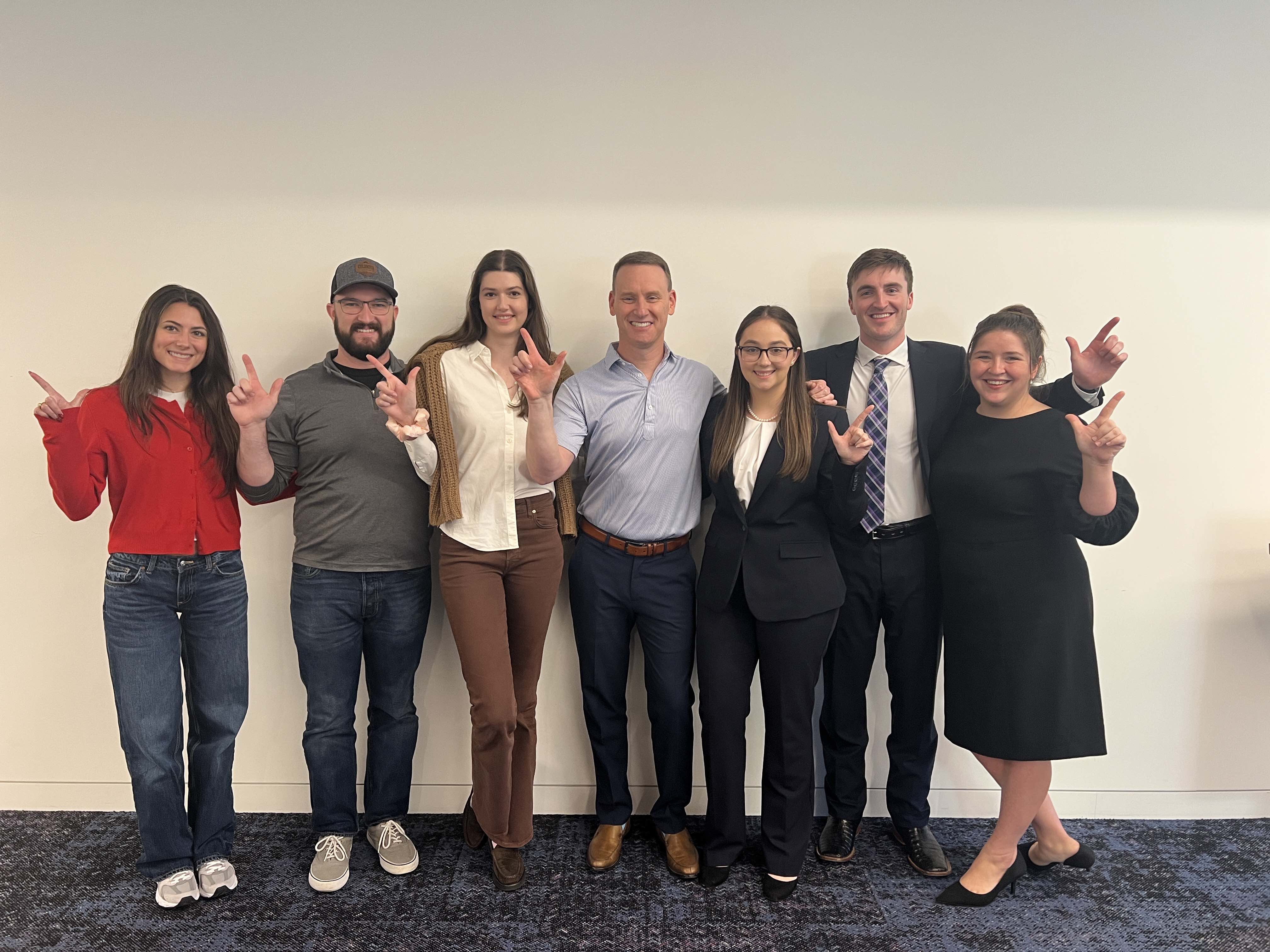 Seven members of the Texas Tech Law advocacy program—Hailey Lowery, Kameron Schultz, Sarah Blakemore, Professor Rob Sherwin, Kiera Figgins, Grant McClure, and Sophia Jenkins—stand together smiling and holding their Guns Up after winning the Chapman, Lewis & Clark Moot Court Invitational.