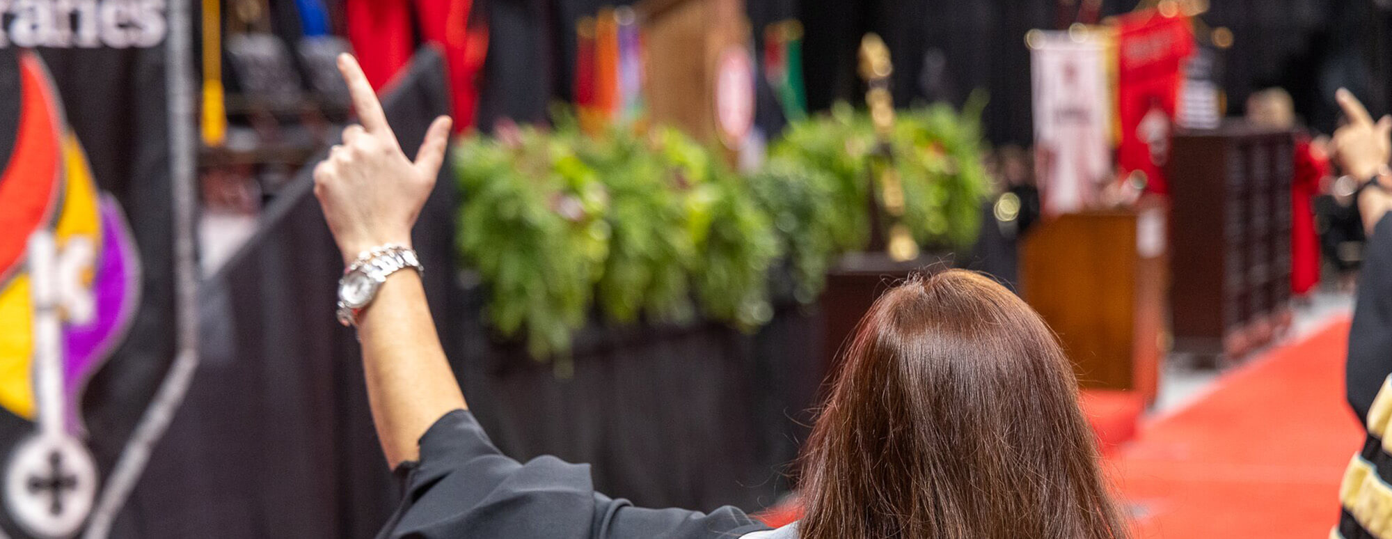 TTU student with her guns up starving at the stage during the graduation ceremony