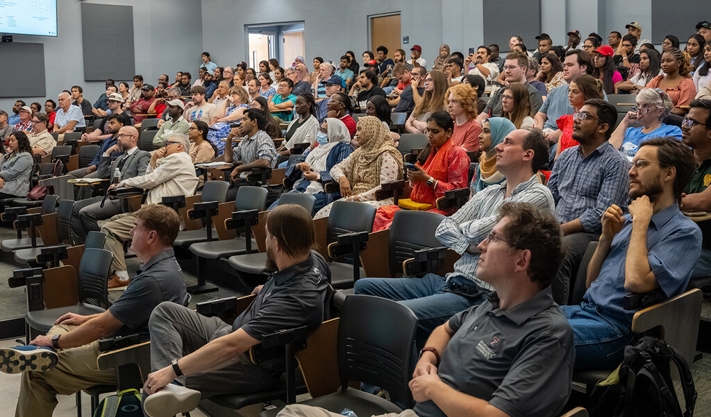 All faculty and graduate student in lecture hall listening to start of the new academic year department meeting.