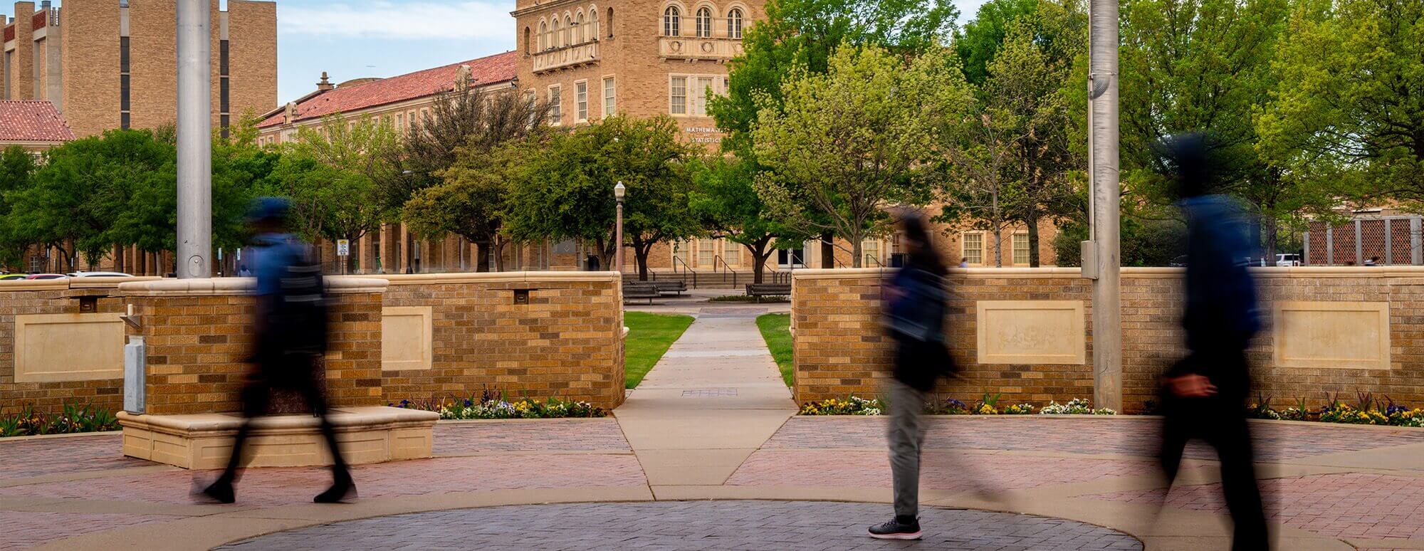 Department of Mathematics and Statistics Building photo taken Memorial Circle with students walking by