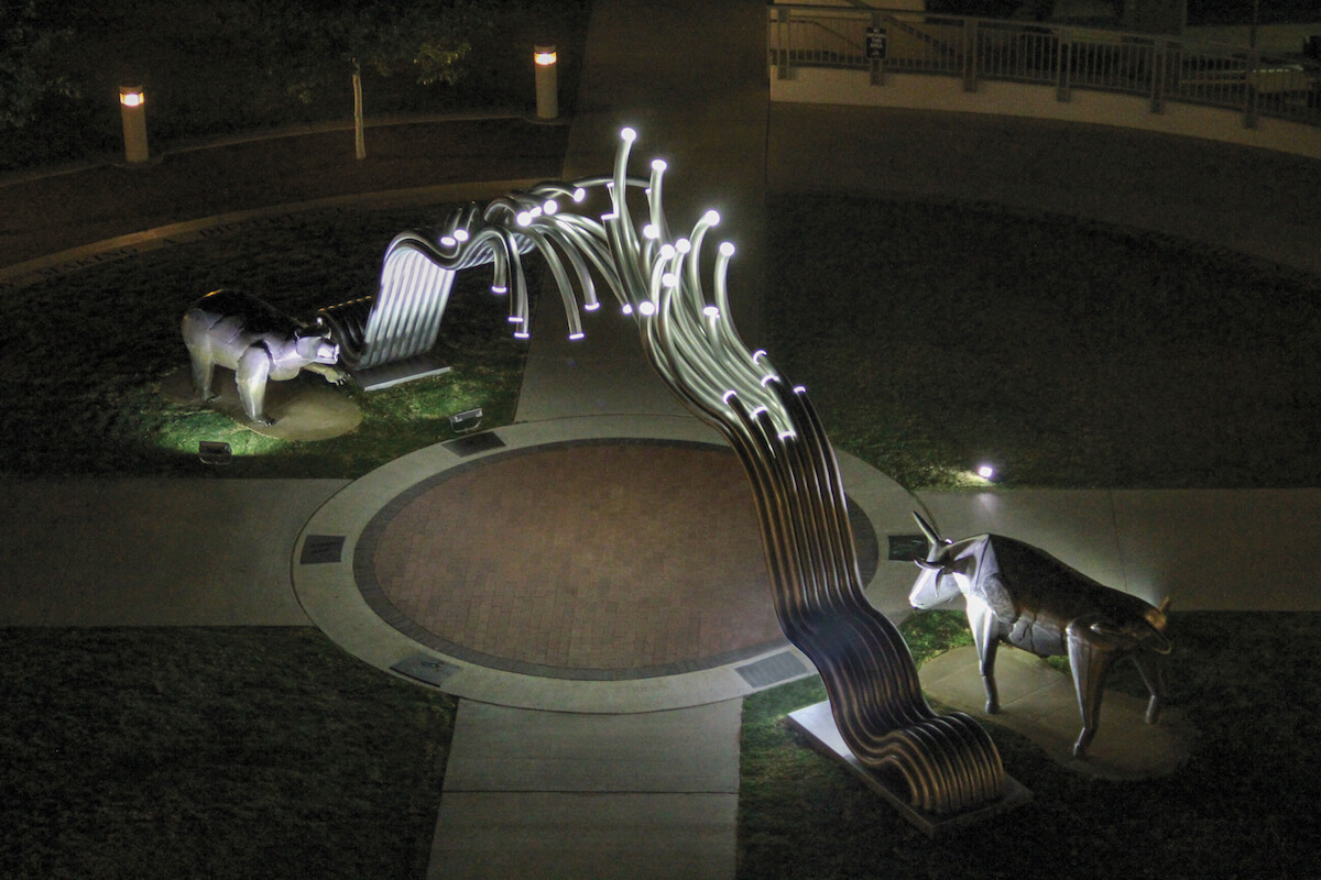 The Bear and Bull statue at night in front of the Rawls College of Business at Texas Tech