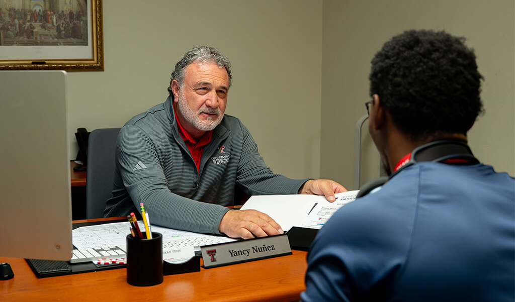 Yancy Nunez sitting at his desk advising a new undergraduate student