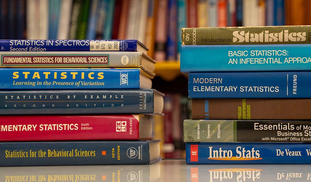 Two stacks of 6 statistics books on a table in the tutoring center
