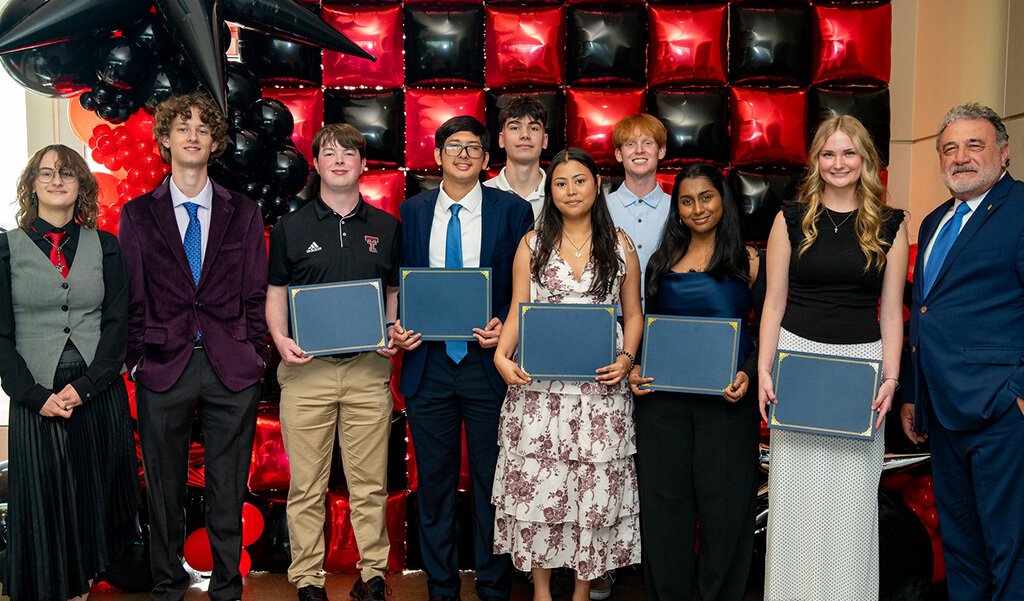 Yancy Nunez standing with undergraduate students at the annual awards and scholarship banquet that received scholarships