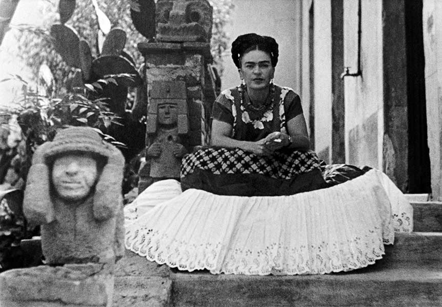 Nickolas Muray, Frida sitting to one side of a sculpture by Mardonio Magana, 1948; Photo: Nickolas Muray, Copyright, Nickolas Muray Photo Archives