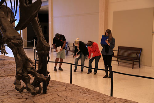 people standing in front of exhibit with clipboards