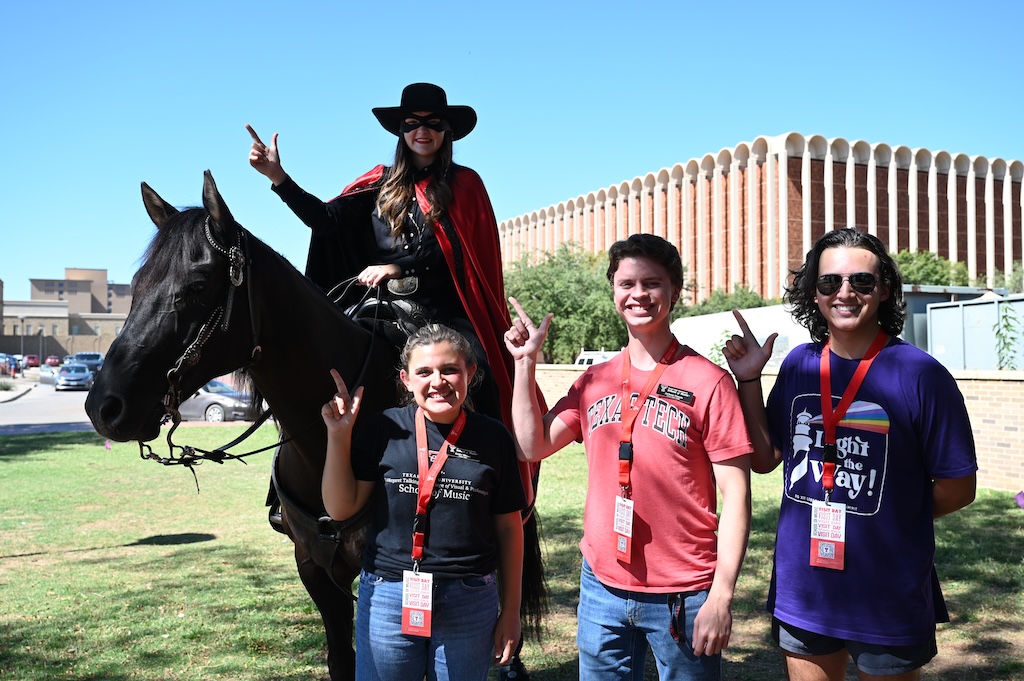 Three Visit Day students standing in front of Masked Rider and Centennial Champion Horse