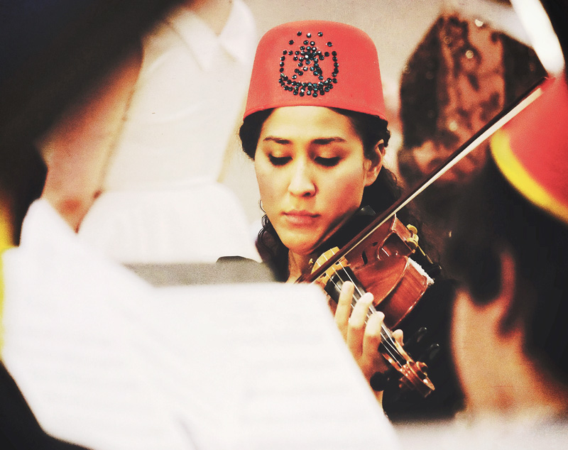 Girl in fez hat playing violin