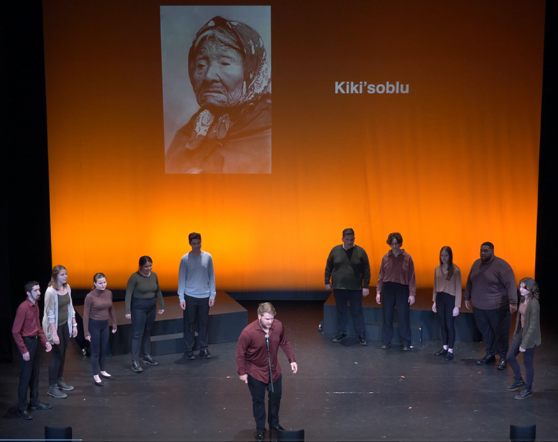 Multiple students in half-circle singing with lead singer in the front middle