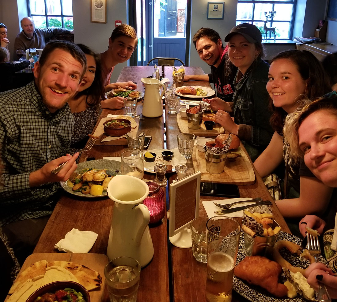 TTU Vernacular study abroad students sitting at a dinner table filled with food