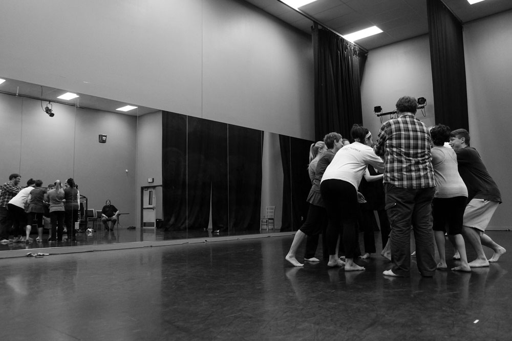 Students in a practice room huddled in a circle