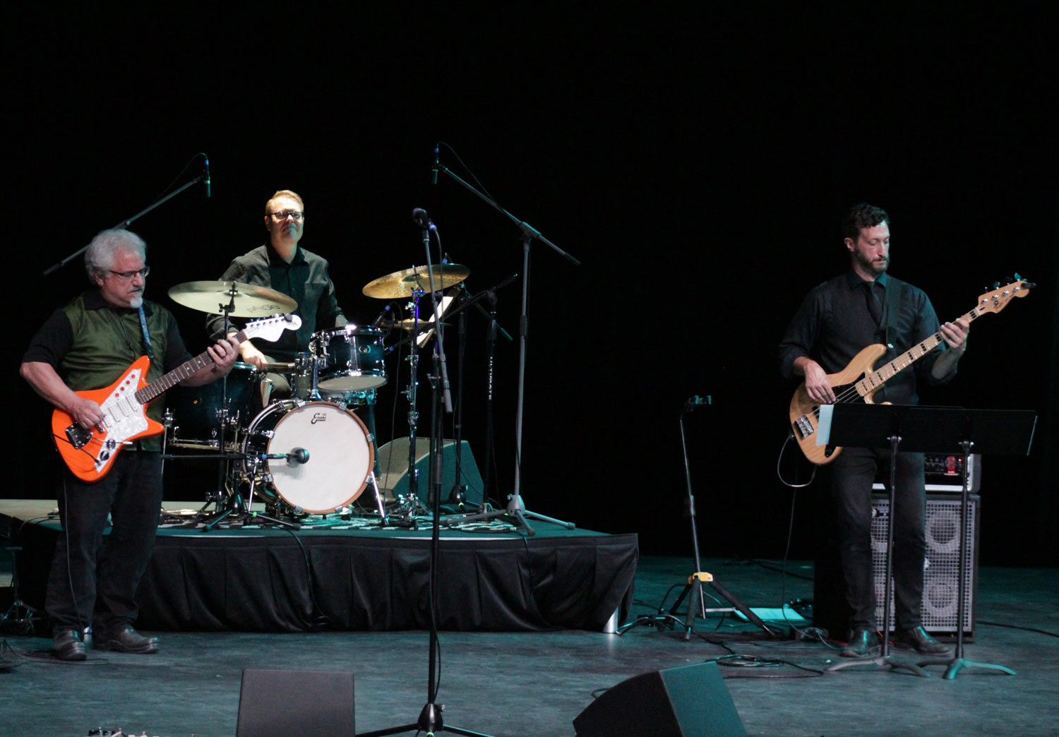 2 guys playing guitar with drummer