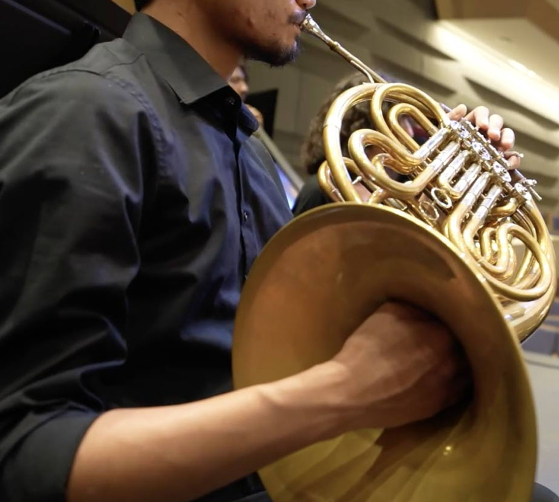 TTU music student playing french horn