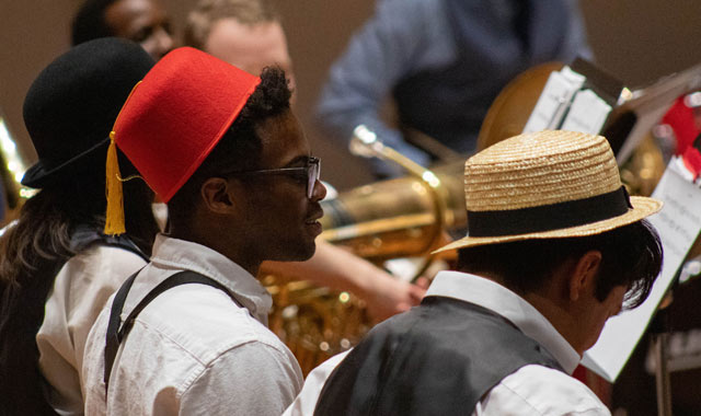 Students wearing different world hats in an orchestra