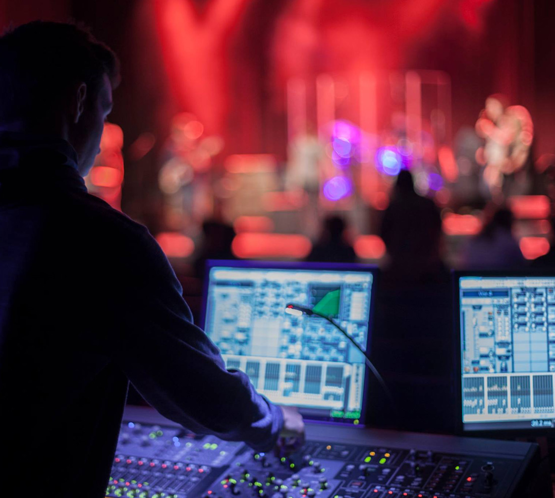 SOM Student behind a music board while a band is on stage