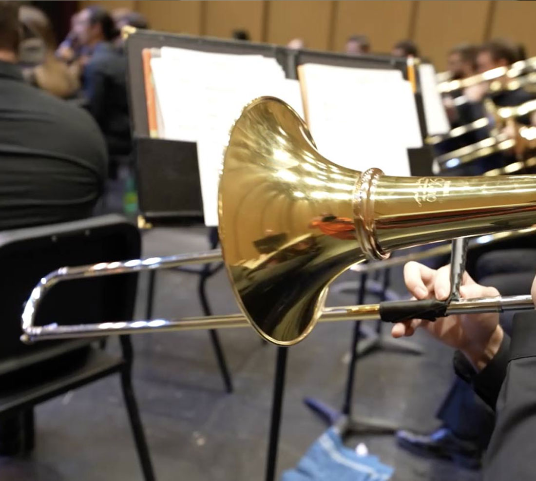 Student playing trombone in orchestra