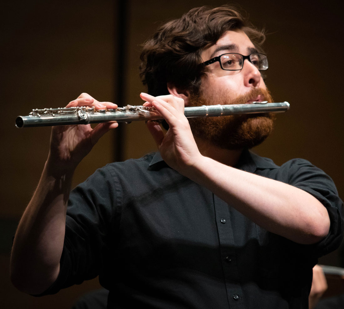 Student playing flute in a performance