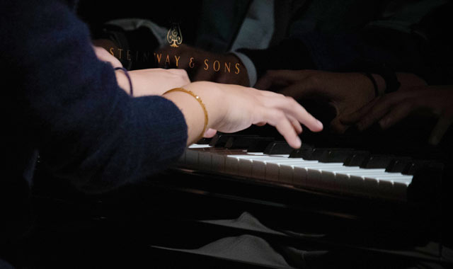 closeup of hands playing piano
