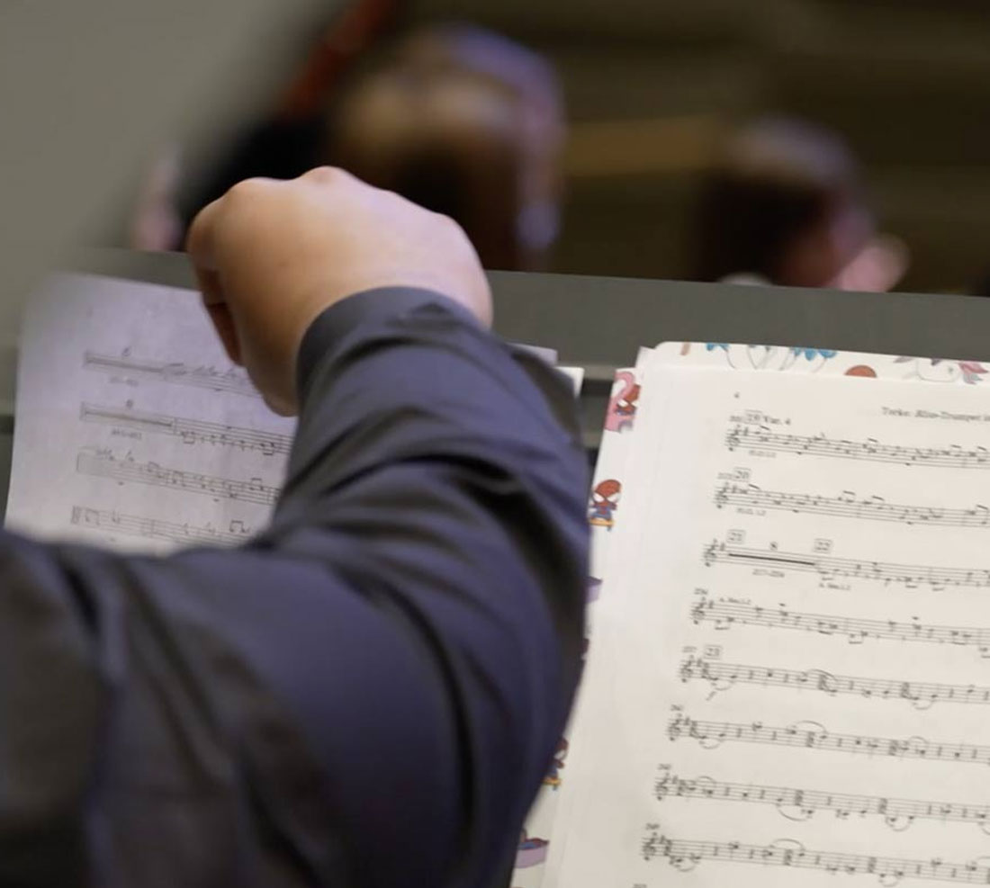 Student turning sheet music on a stand