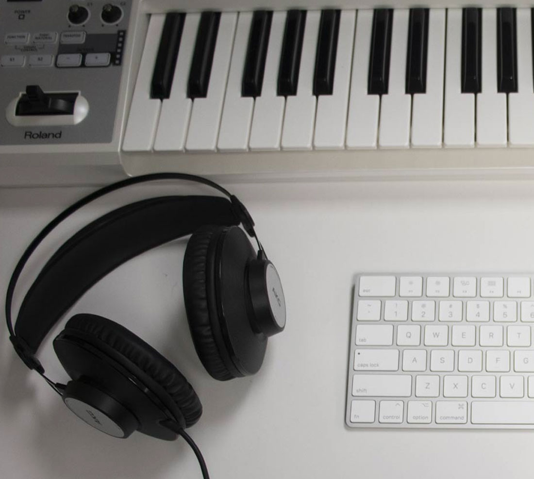 Headphones on table with music keyboard and computer keyboard