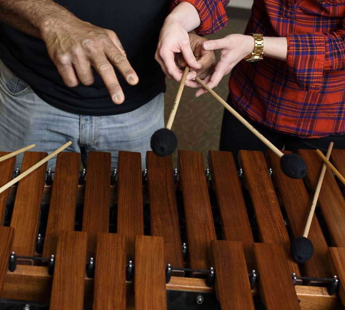 Faculty & student practicing on a xylophone