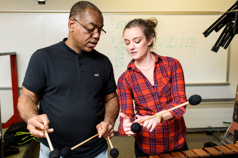 Faculty and student practicing xylophone