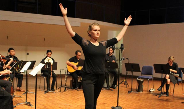 Student getting ready for dance performance with  orchestra surrounding her