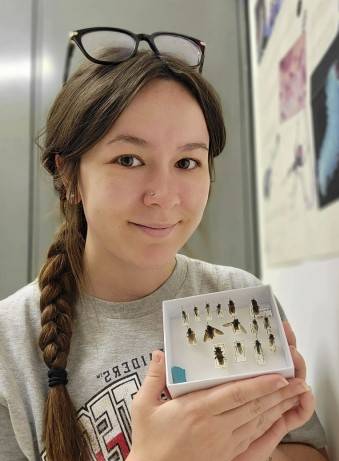 Portrait of Rachael Johnston holding a unit tray with robber flies
