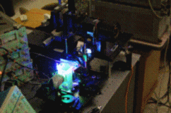 Experimental projection system. Foreground: Green and blue LEDs illuminating a color combining prism; Background: the DMD chip and projection optics.
