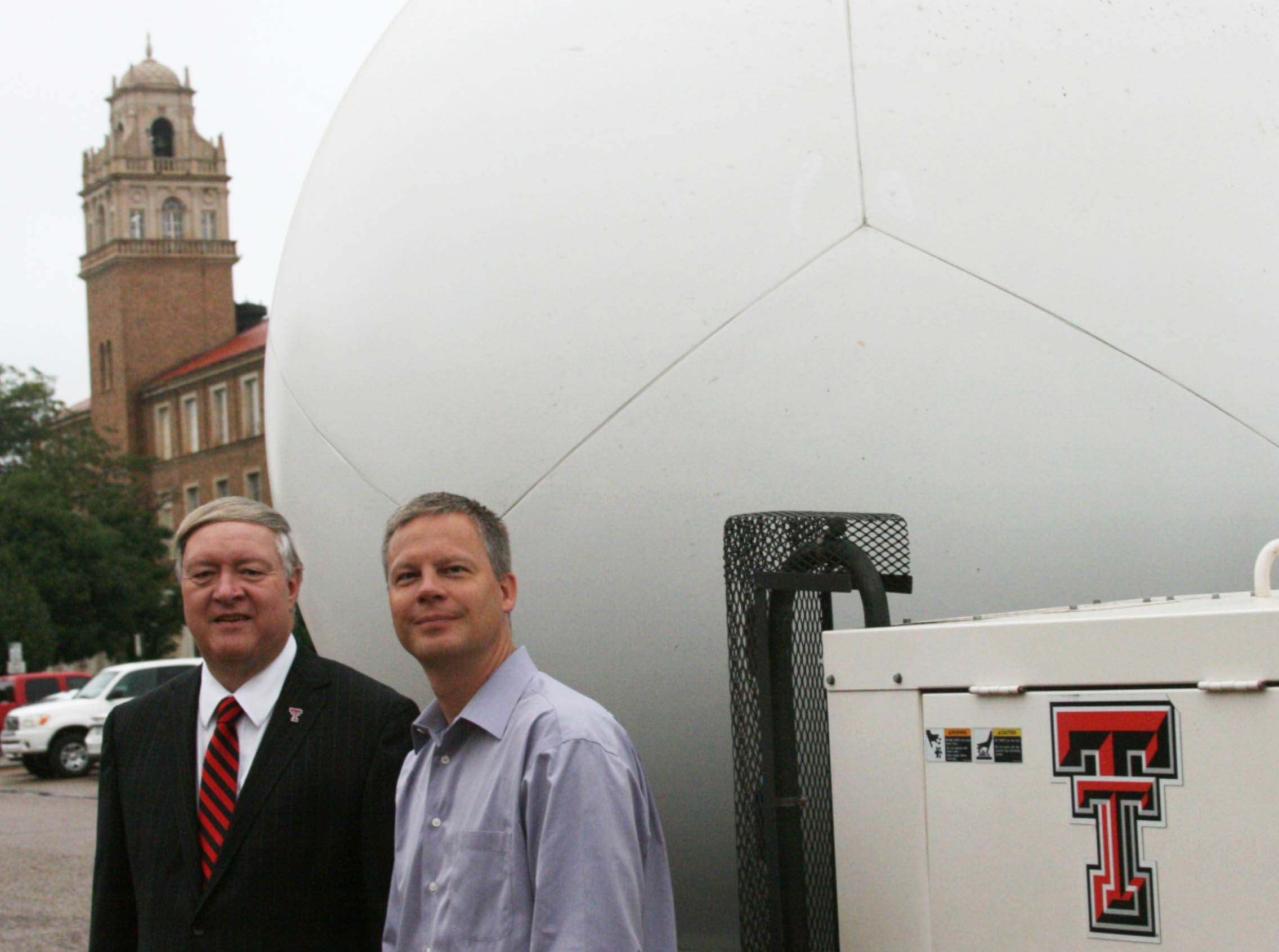 TTU President Dr. Nellis chats with former NWI Director Dr. John Schroeder by one of the NWI's Ka-band radar trucks. 