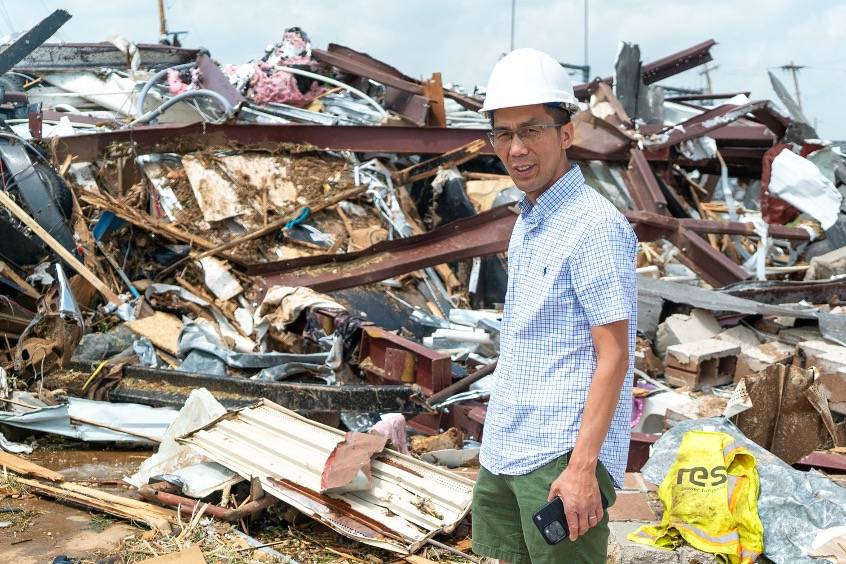 Dr. Zuo in front of Tornado Damage