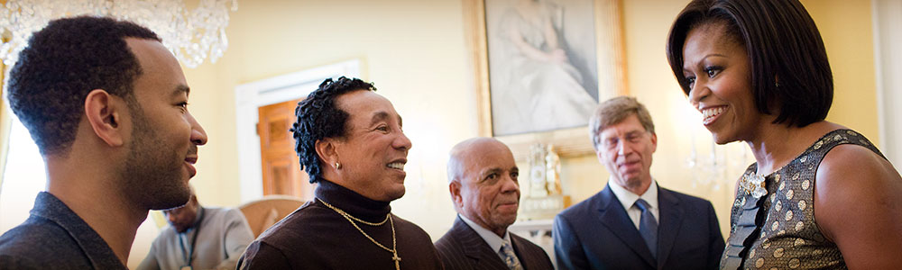 First Lady Michelle Obama greets John Legend, Smokey Robinson, Berry Gordy, and Bob Santelli in the Old Family Dining Room of the White House.