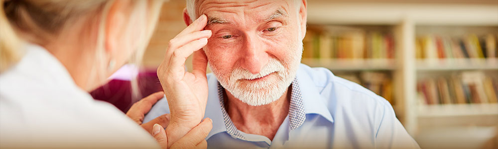 Older man with troubled expression speaking with younger woman.