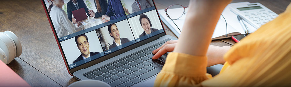 Women teleconferences with colleagues on her laptop.