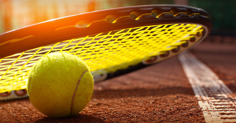  Tennis racket and ball on court.