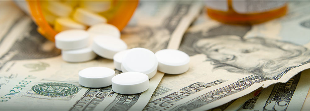 prescription bottle spilling pills over dollar bills