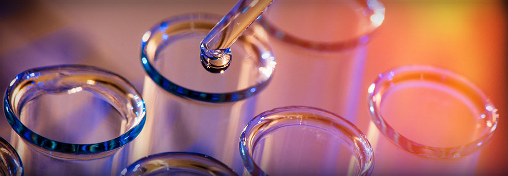 Pipette dripping drop of water over test tube.