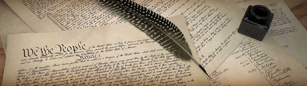 Closeup of papers with the U.S. constitution, quill pen and inkwell.