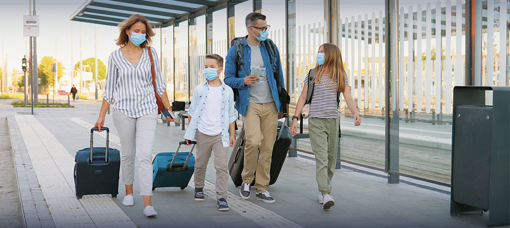 Masked family walking with luggage