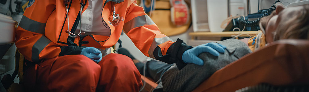 Paramedic comforting patient inside ambulance.