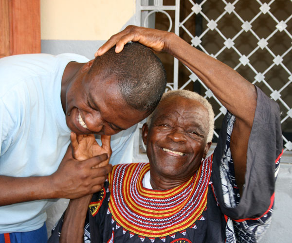 Sixtus Atabong embracing and laughing with his father during a mission trip.