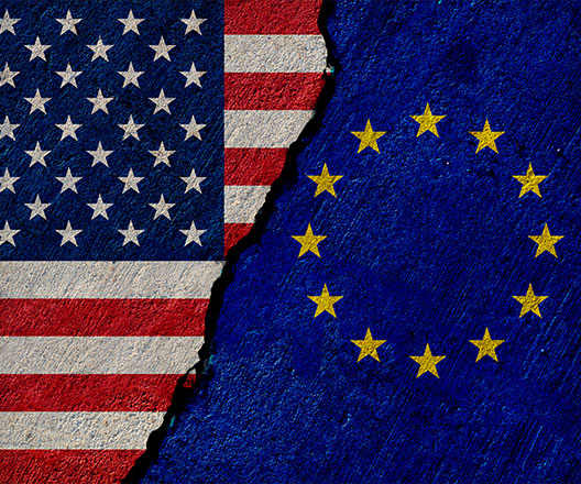 United States and European Union flags painted on concrete wall.