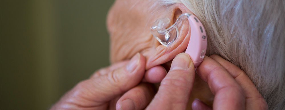 Woman being fitted with a hearing aid.
