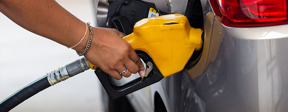  Closeup of hand with fuel dispenser filling a car with gas.