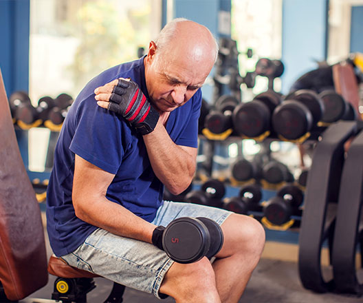 Older man lifting dumbbells in gym