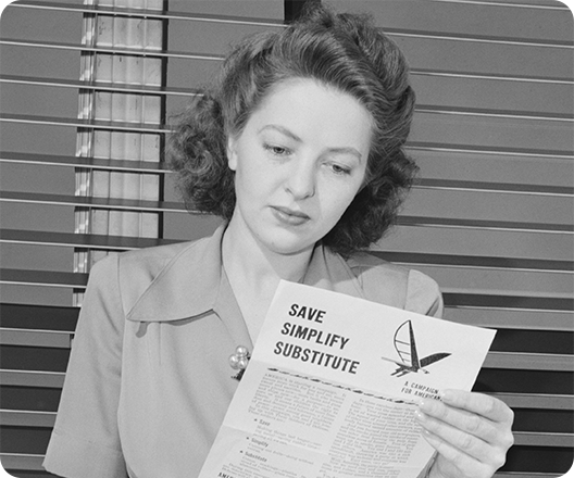World War II era photo of woman reading rationing pamphlet