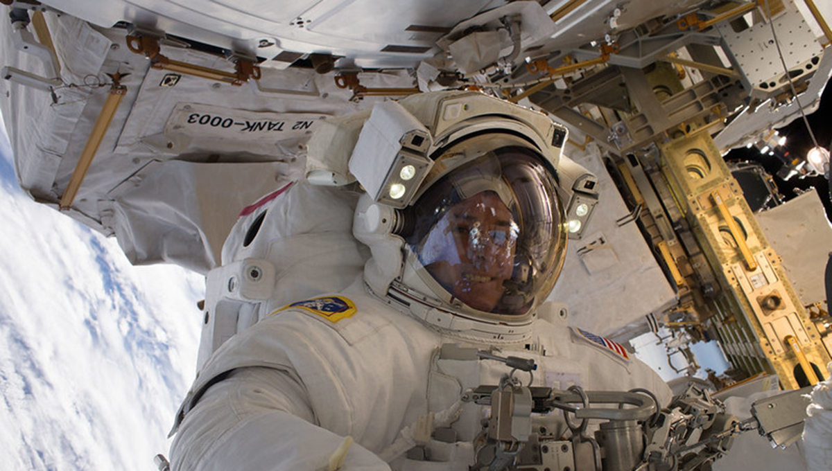 Kimbrough during an EVA Kimbrough wears a spacesuit while surrounded by large equipment as he faces the camera and smiles