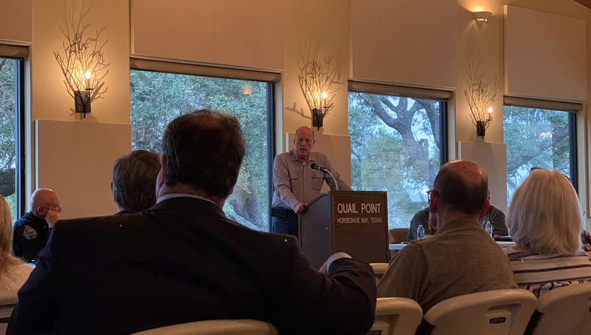 OLLI speaker shares expertise on gun ownership responsibilities A man wearing a light blue shirt stands behind a podium and looks out at his audience as the sit in chairs facing the speaker